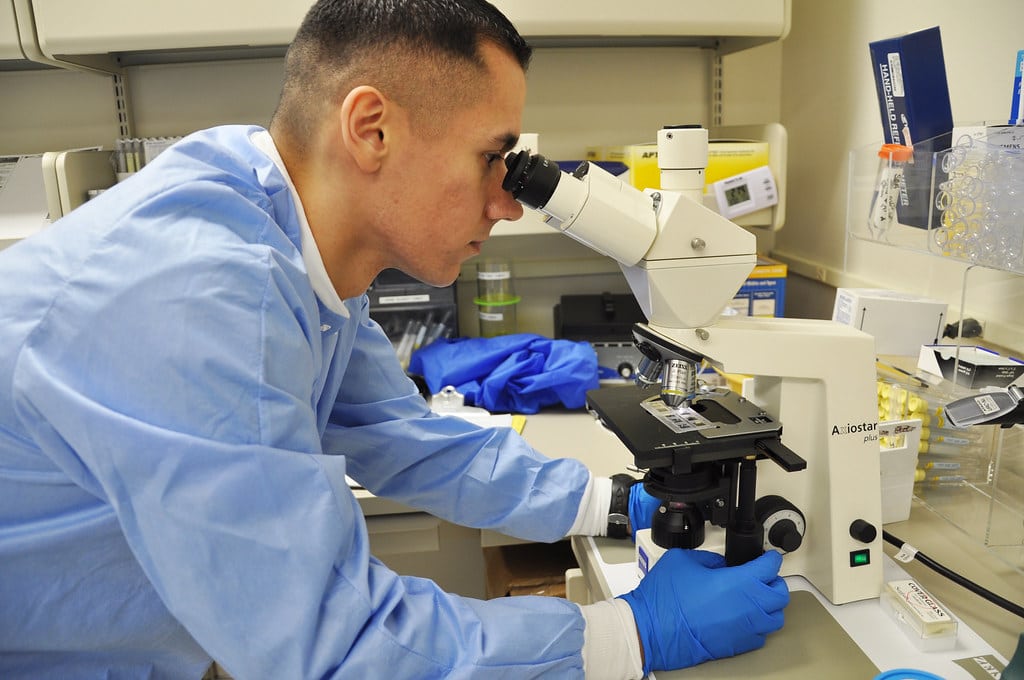 lab technician looking in a microscope
