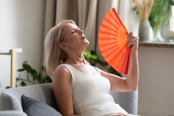 mature woman in a hot flash with orange fan